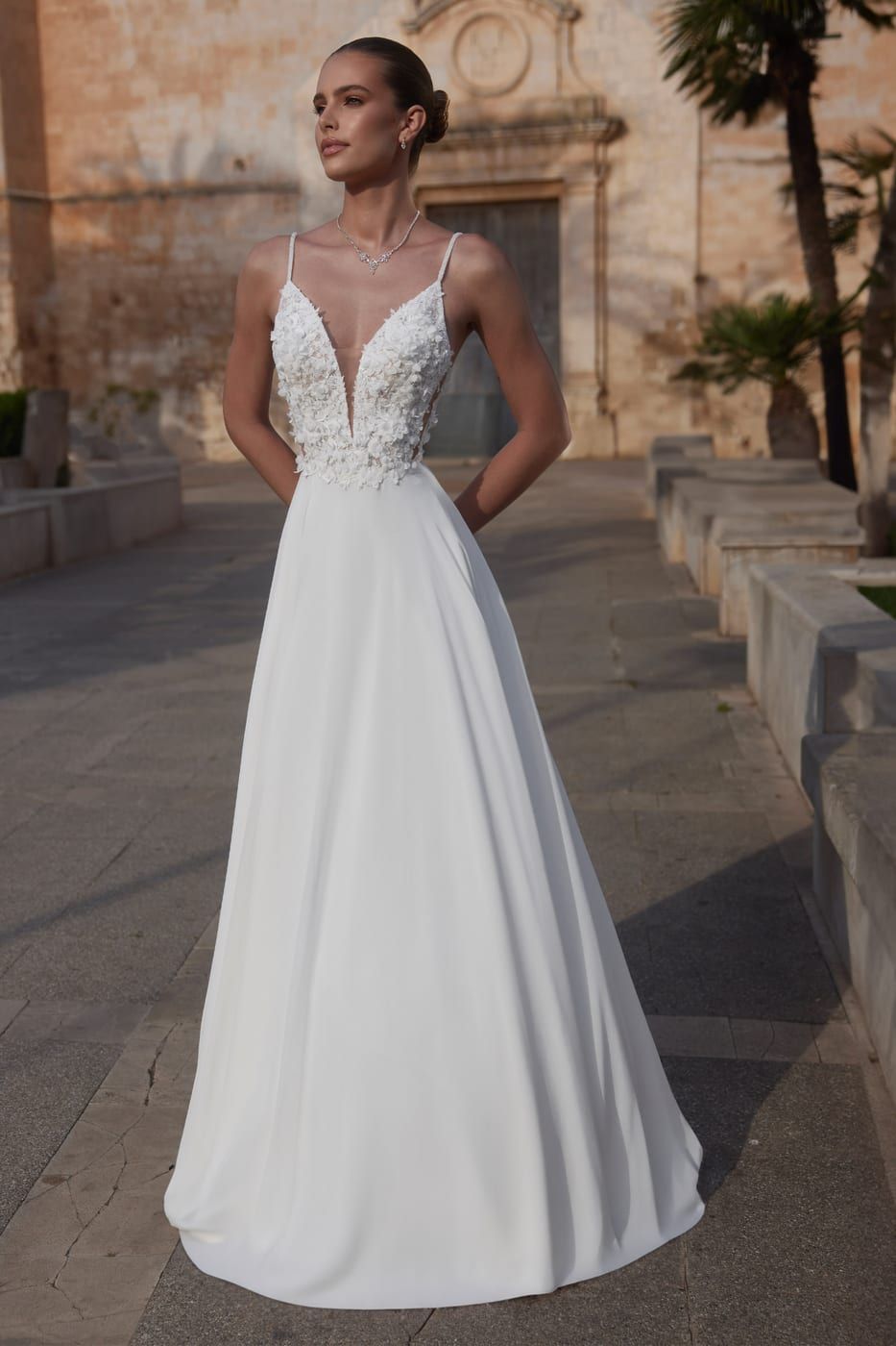 A-line wedding gown with a floral-appliqué bodice, in evening sunlight